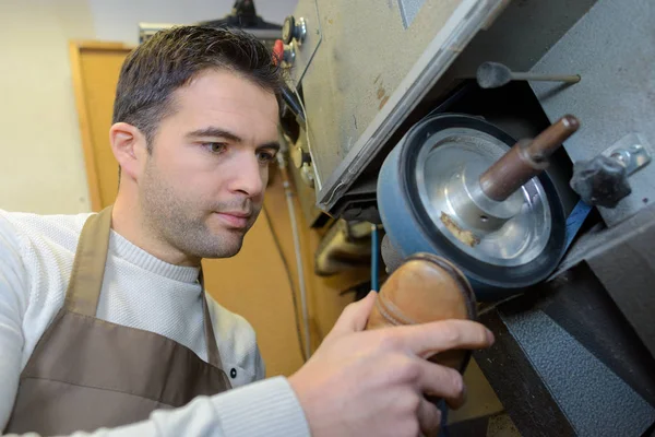 Schoenmaker tussenzool van een schoen tegen het wiel draaiende houden — Stockfoto