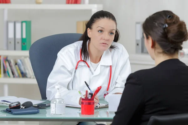 Arts in het kantoor in gesprek met een patiënt — Stockfoto
