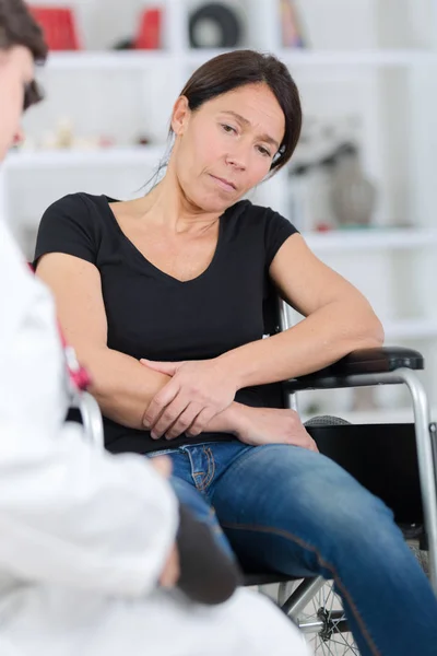 Disabled woman complains about arm pain during consultation — Stock Photo, Image