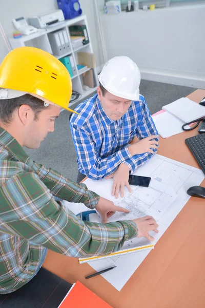 Architects gathered around plans — Stock Photo, Image