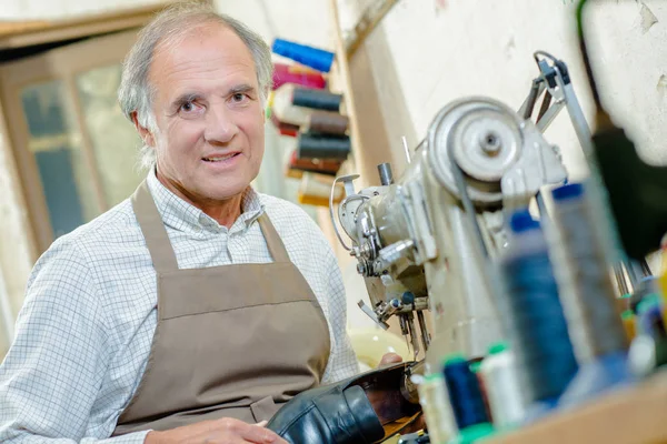 Schoenmaker en machine en schort — Stockfoto