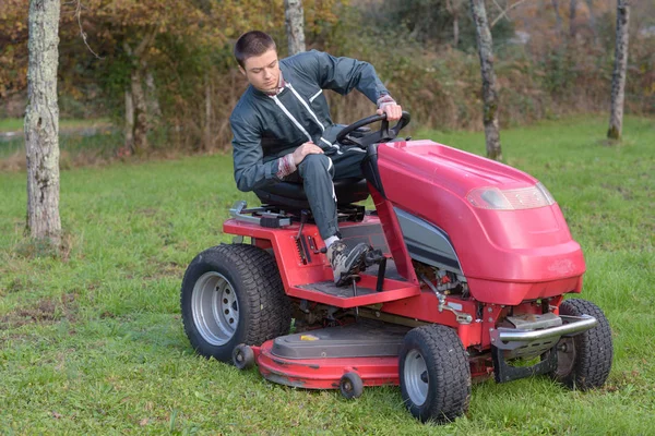 若い男が運転芝刈り機 — ストック写真