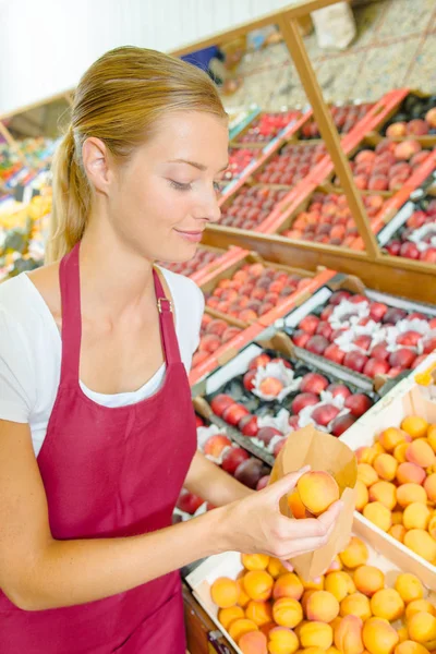 Fruit kraam werknemer en apple — Stockfoto