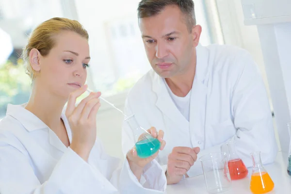 Uomo e donna che eseguono esperimenti in laboratorio — Foto Stock