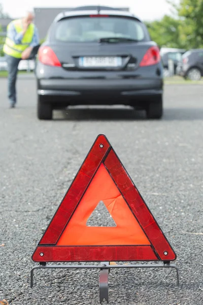 Triángulo de advertencia detrás del coche parado — Foto de Stock