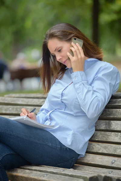 Femme assise sur un banc — Photo