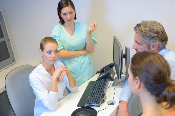 Dokters in overleg met de middelste leeftijd paar — Stockfoto