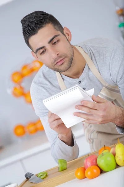 Junger Mann folgt Rezept zu Hause — Stockfoto