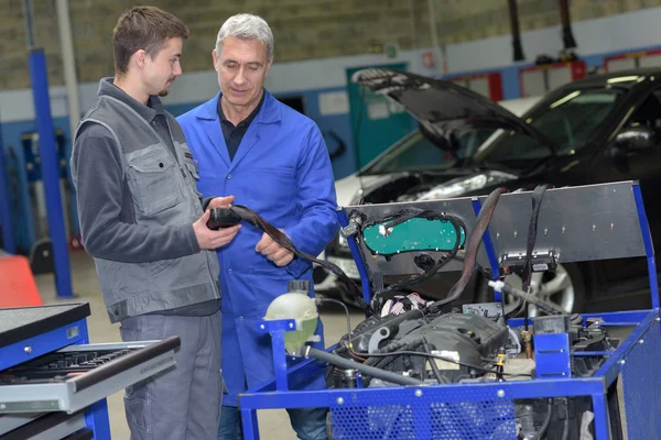 De baan leren tijdens een praktijkstage in een garage — Stockfoto