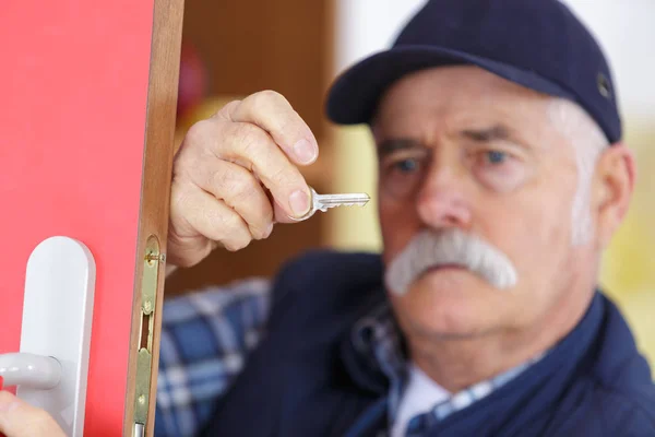 Hombre mayor reparando cerradura de puerta —  Fotos de Stock