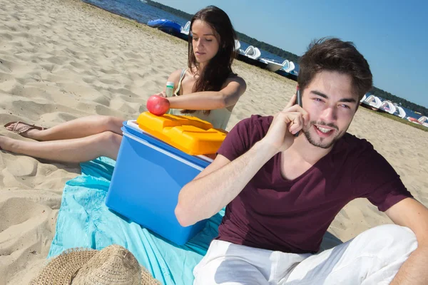 Glada tonåringar ringer sina vänner medan du njuter av stranden — Stockfoto