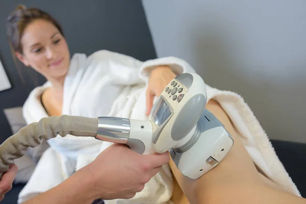 Mulher recebendo tratamento a laser em suas pernas — Fotografia de Stock