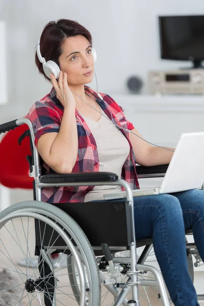 Disabled woman listening to music with headphones — Stock Photo, Image