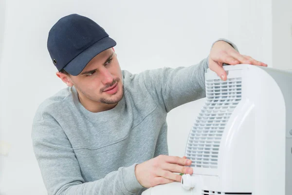 Joven técnico instalando sistema de aire acondicionado en interiores — Foto de Stock