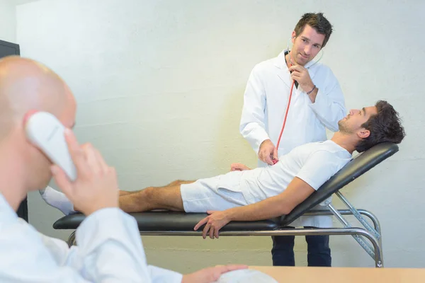 Medico con stetoscopio, collega al telefono — Foto Stock