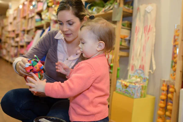 Fiatal anya lánya vásárlás a játék boltban — Stock Fotó