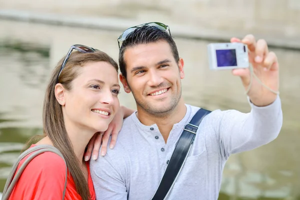 Couple prenant des photos d'eux-mêmes avec un appareil photo numérique — Photo