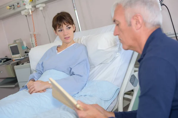 Hombre leyendo al paciente en el hospital — Foto de Stock