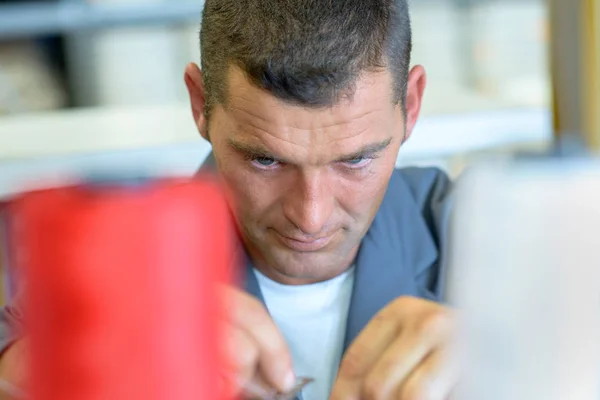 Muž vláken bavlny na šicí stroje — Stock fotografie