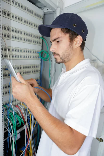 Konzentrierter Elektriker, der Sicherheitsverfahren anwendet, während er an der Schalttafel arbeitet — Stockfoto