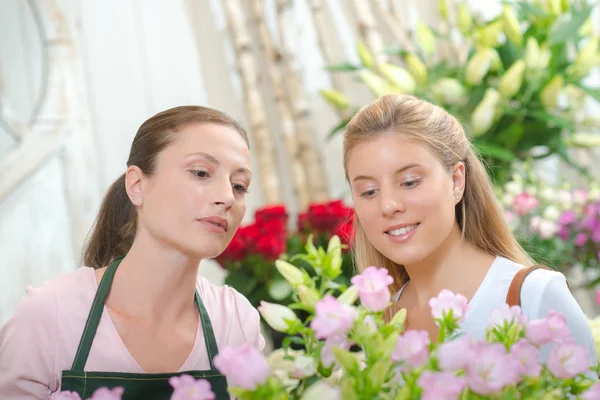 Blumenhändler überreicht Blumenstrauß an Kunden — Stockfoto