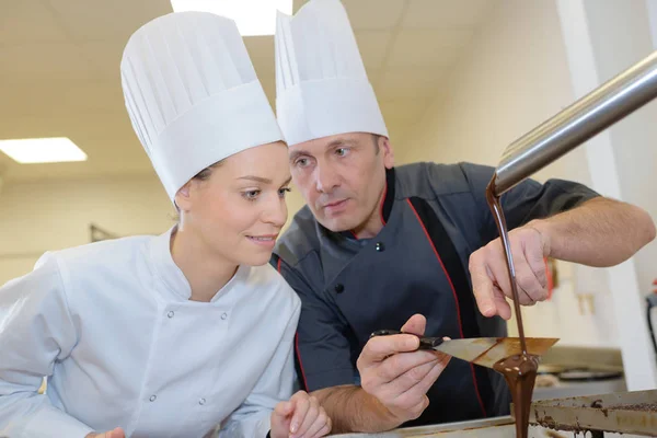 Dos artesanos haciendo salsa de chocolate — Foto de Stock