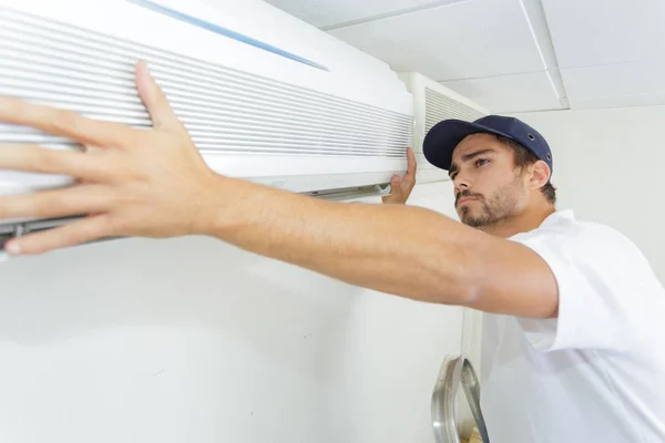 Técnico cara cuidadosamente instalar novo ac — Fotografia de Stock