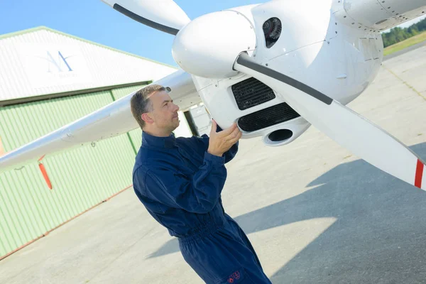 Mechanic looking at aircraft propellor — Stock Photo, Image