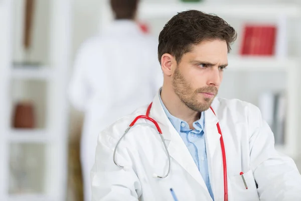 Schöner junger Arzt bei der Arbeit in seinem Büro — Stockfoto