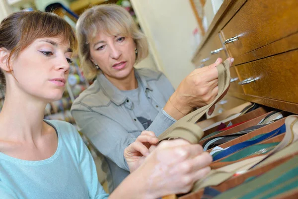 Twee dames bijpassende ritsen in ambachtelijke lade — Stockfoto