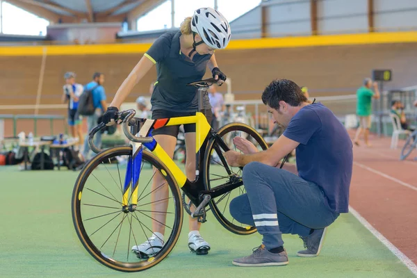 Tränare som arbetar på cyklist s cykel — Stockfoto