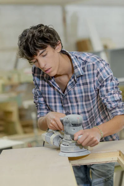 Young carpenter using a sander — Stock Photo, Image