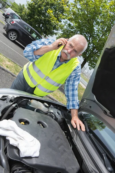 Senior sucht Hilfe bei Reparatur festgefahrenen Fahrzeugs — Stockfoto