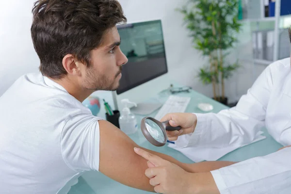 Close-up of doctors hands checking mans moles — Stock Photo, Image