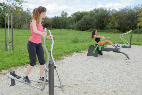 Kvinnor som arbetar ute på utrustning i park — Stockfoto