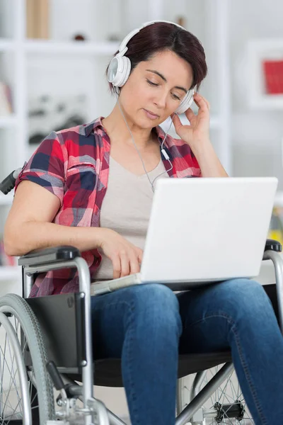 Gehandicapte vrouw in rolstoel met laptop — Stockfoto