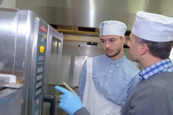 Chef professionisti guardando il forno — Foto Stock