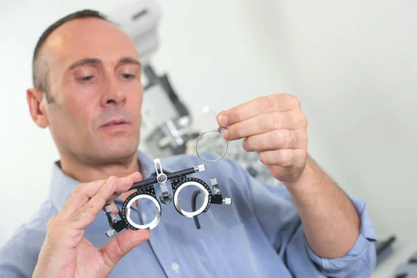 Optician colocando lente em óculos de olho — Fotografia de Stock