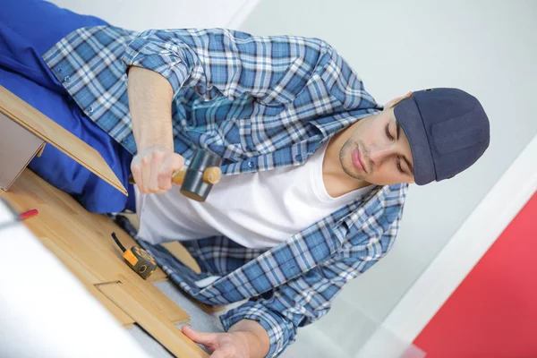 Ung tekniker installerar golv på byggarbetsplats — Stockfoto