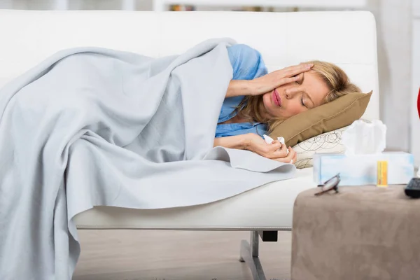 女性がベッドで眠りに落ちる前に薬を服用 — ストック写真