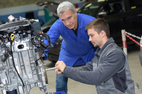 Mécanicien automobile montre l'entretien stagiaire du moteur de voiture — Photo