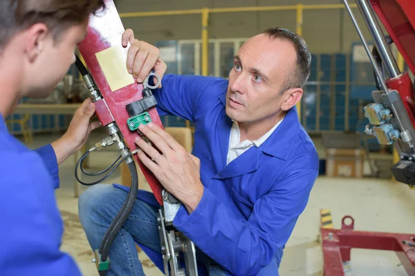 Man explaining hydraulics to trainee — Stock Photo, Image