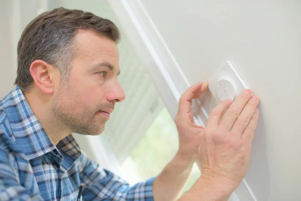 Elektriker installiert eine Steckdose — Stockfoto