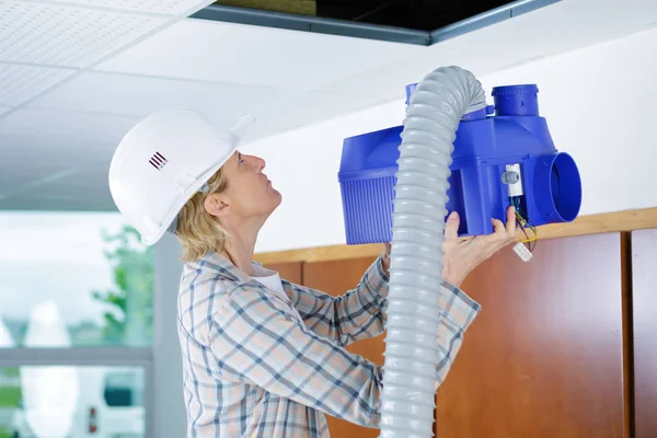 Trabajador femenino instalación de sistema de ventilación en el techo de edificios —  Fotos de Stock