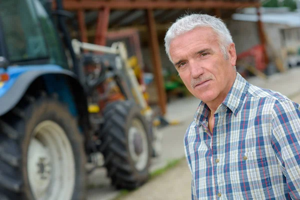 Mannen som poserar med en traktor — Stockfoto