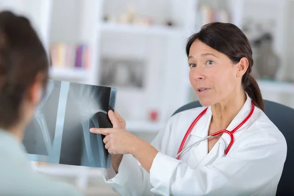 Dentista donna e la sua paziente femminile guardando l'immagine a raggi X — Foto Stock