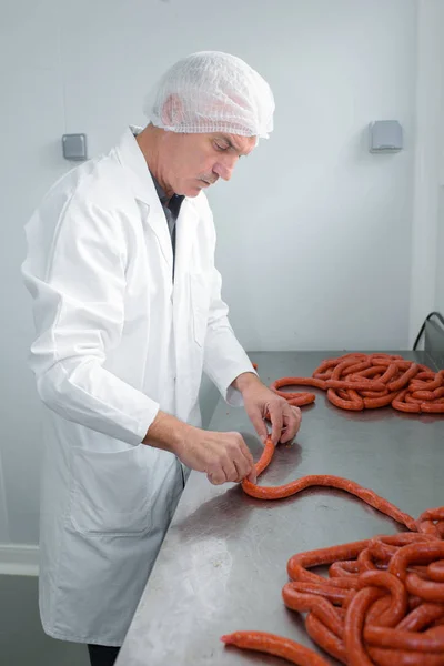 Butcher making sausages and butcher — Stock Photo, Image