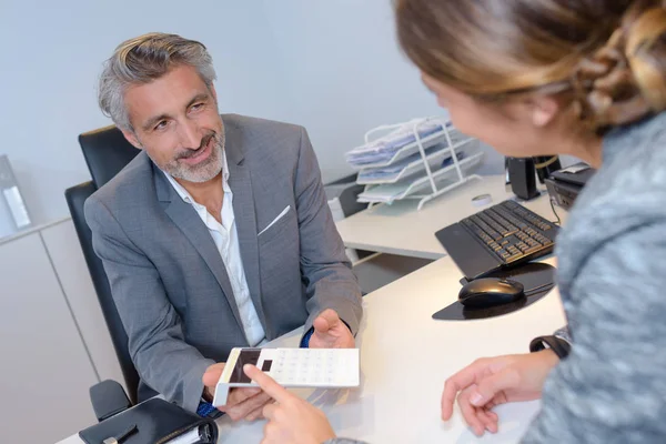 Personer som tittade på beräkningar under affärsmöte — Stockfoto