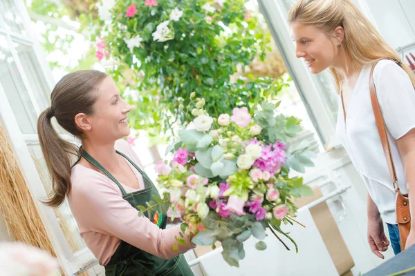 Florista dando a senhora um arranjo de flores — Fotografia de Stock