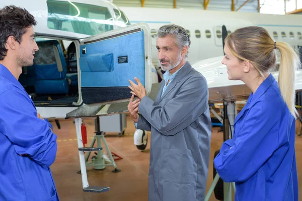 Students looking in compartment of aircraft — Stock Photo, Image